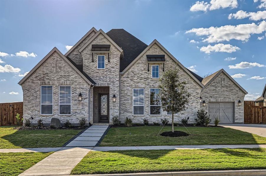 View of front of property with a front yard and a garage