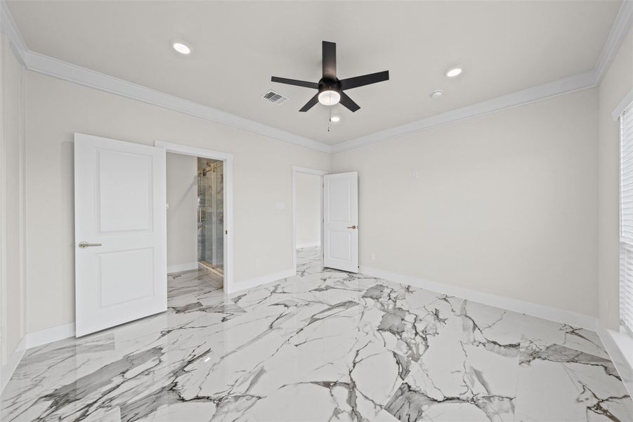 Polished stone tile flooring and crisp crown molding create an elegant, refined atmosphere.