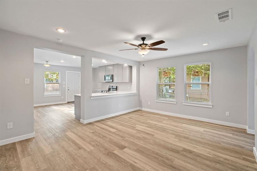 Unfurnished living room featuring light hardwood / wood-style floors and ceiling fan