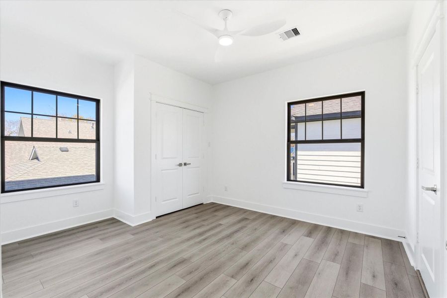 Bedroom #2 on the first floor is filled with natural light from two picture windows, creating a bright and comfortable space. This room features two closets, one located in the bedroom and another in the ensuite bath, giving you plenty of storage. Bedroom #2 on the first floor is filled with natural light from two picture windows, creating a bright and comfortable space. This room features two closets, one located in the bedroom and another in the ensuite bath, giving you plenty of storage.