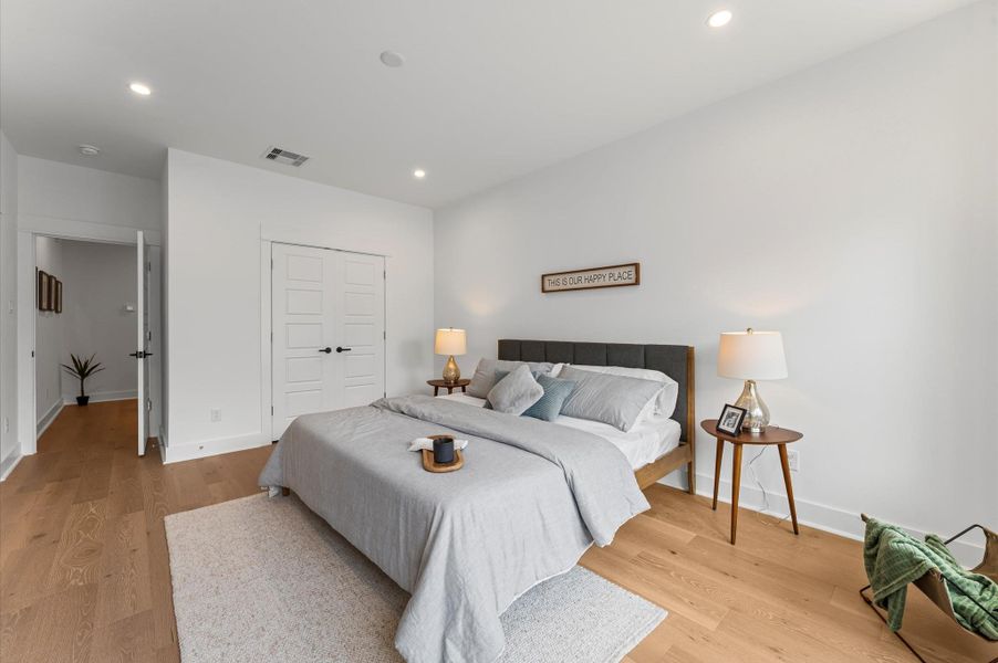 This spacious second-floor primary bedroom exudes modern elegance with its sleek engineered wood flooring that adds warmth and texture underfoot. Soaring high ceilings amplify the sense of openness, allowing natural light to cascade in and highlight the room’s architectural charm. Whether styled with minimalist furnishings or layered with cozy accents, the space offers a serene retreat elevated by its refined finishes and elevated vantage point.