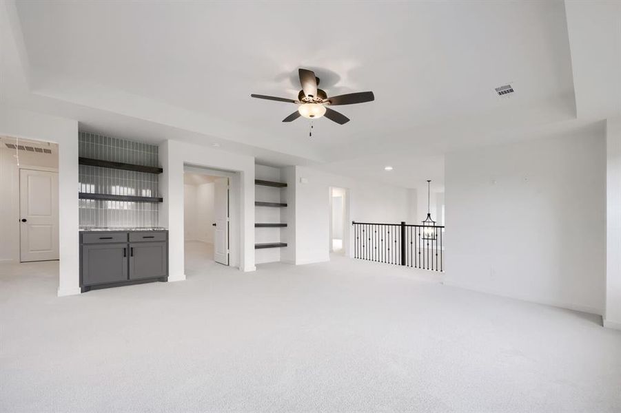 Spacious interior room featuring light-toned carpeting and a tray ceiling