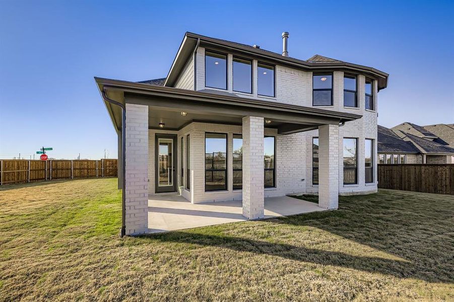 Rear view of house with a patio, brick siding, and a fenced backyard