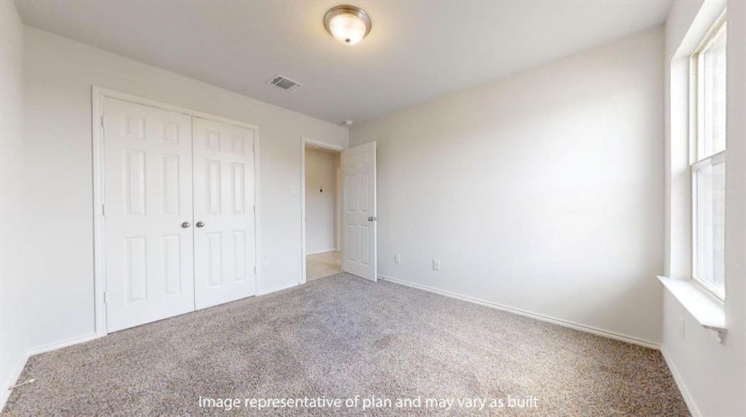 Carpeted room featuring a double-door closet, a single window, and a flush mount ceiling light Carpeted room featuring a double-door closet, a single window, and a flush mount ceiling light