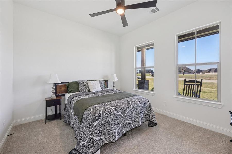 Bedroom featuring light colored carpet and a ceiling fan Bedroom featuring light colored carpet and a ceiling fan