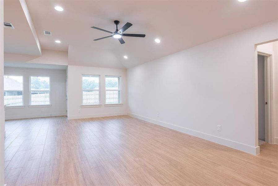 Unfurnished room featuring light wood finished floors, recessed lighting, ceiling fan, and vaulted ceiling
