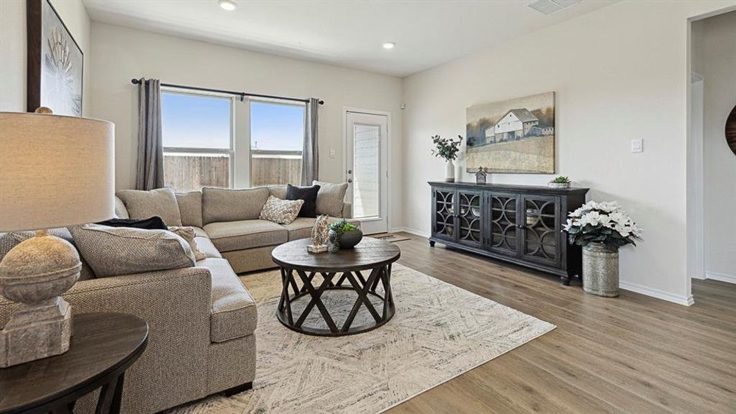 The living area features durable flooring, a large window, and a door providing exterior access