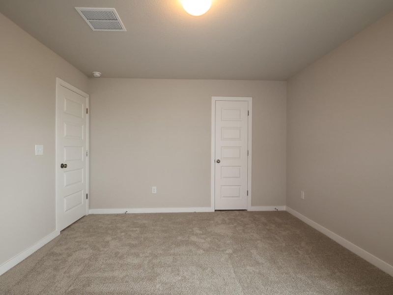 An inviting room awaits personalization with its soft carpet flooring and classic panel doors.