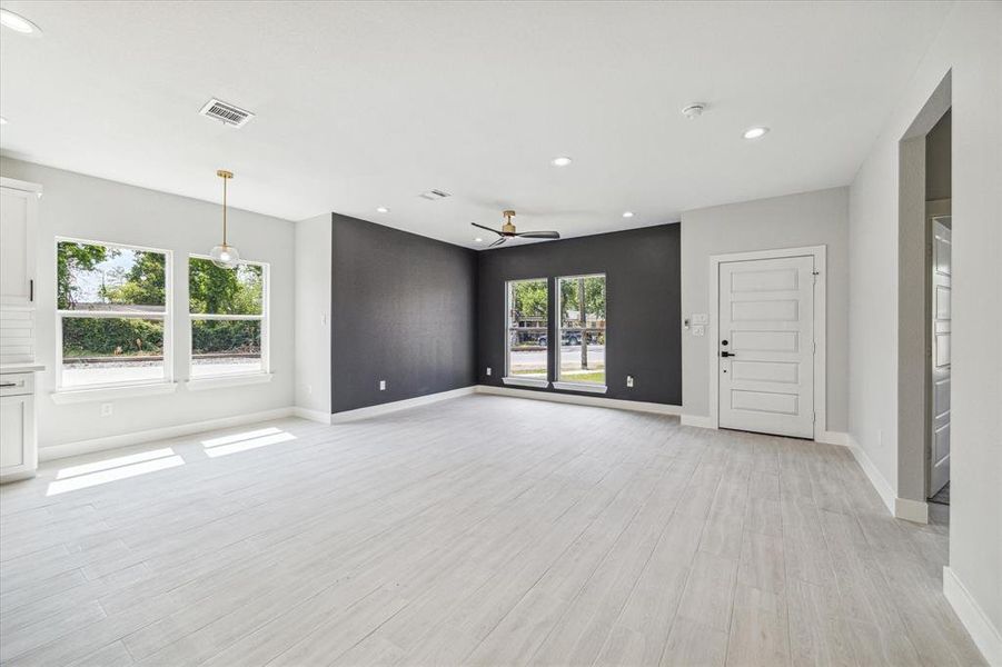 The spacious open concept living area is adorned with LED lighting and an accent wall