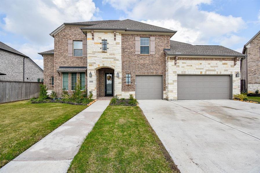 6119 Glass Peak Lane features a stunning blend of brick and stone, showcasing a timeless architectural style. The exterior boasts a rich, warm-toned brick that complements the earthy hues of the natural stone accents.