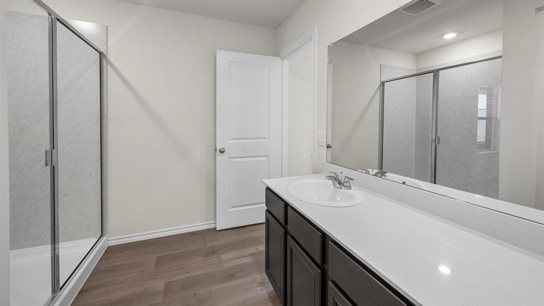 Bathroom featuring a shower stall, vanity, dark wood-type flooring, and recessed lighting