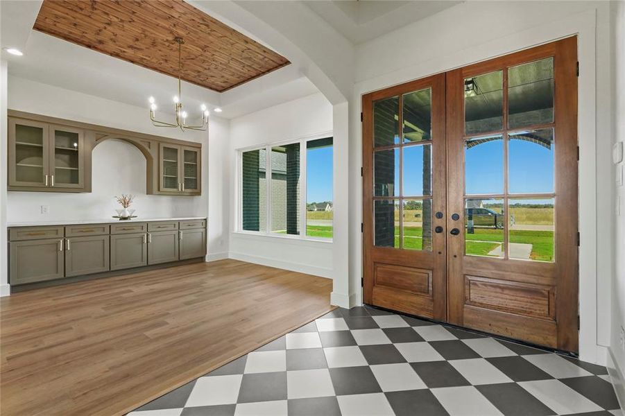 Doorway with french doors, a raised ceiling, tile patterned floors, arched walkways, and recessed lighting Doorway with french doors, a raised ceiling, tile patterned floors, arched walkways, and recessed lighting