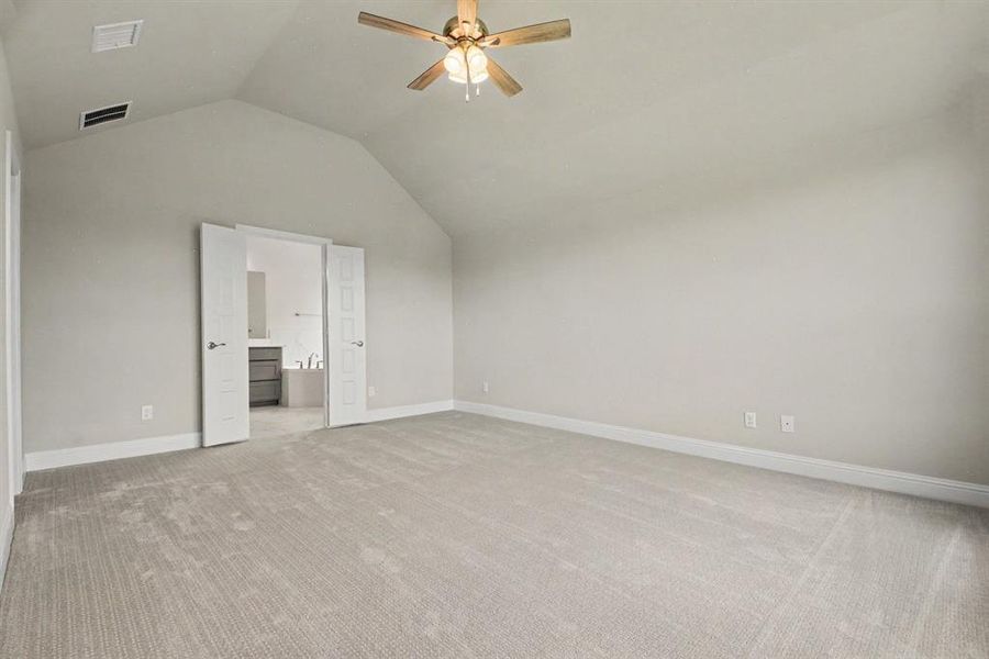 Spacious room featuring vaulted ceilings, light-toned carpeting, a ceiling fan with integrated lighting, and white baseboards Spacious room featuring vaulted ceilings, light-toned carpeting, a ceiling fan with integrated lighting, and white baseboards