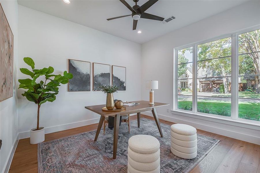 Office space with hardwood / wood-style floors and ceiling fan