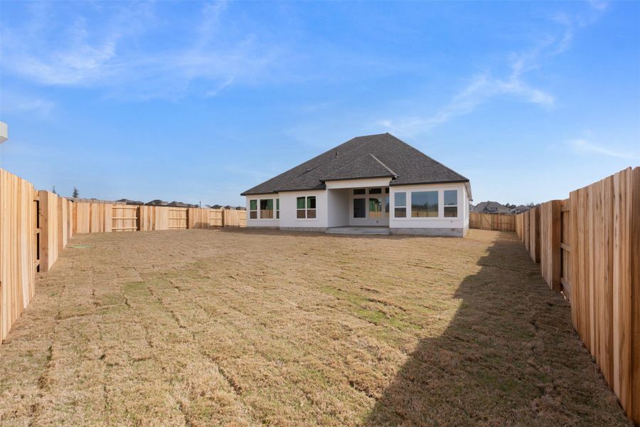 Back of property with a patio, a fenced backyard, and roof with shingles