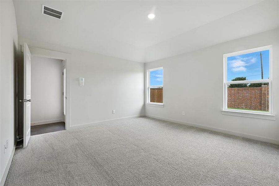 Carpeted spare room featuring baseboards and vaulted ceiling Carpeted spare room featuring baseboards and vaulted ceiling