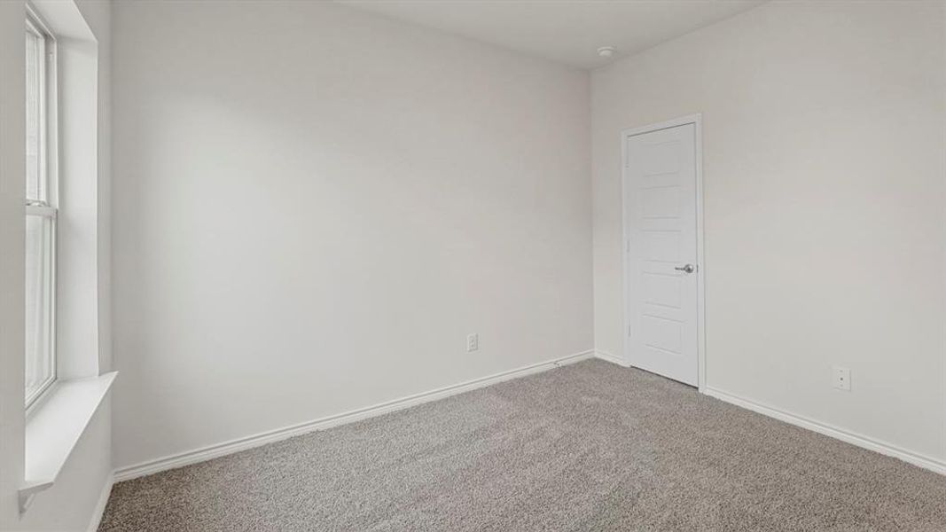 Neutral-toned interior room featuring light gray carpet flooring and white painted walls