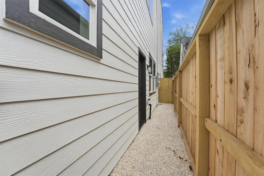 Private side yard with a pebble pathway, wood fencing, and easy outdoor access. Low maintenance space with added privacy.