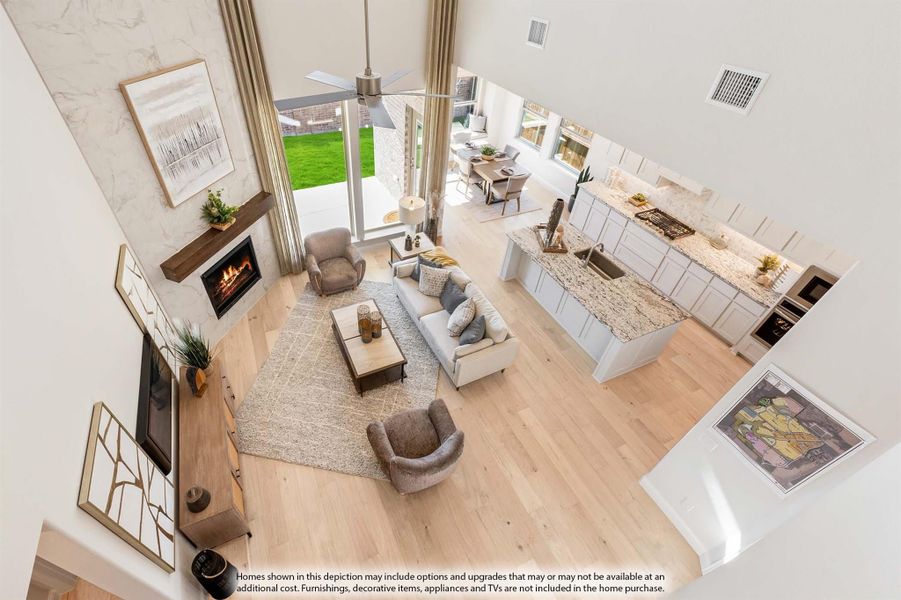 Open-concept living area with fireplace, vaulted ceiling, and kitchen with granite island viewed from above Open-concept living area with fireplace, vaulted ceiling, and kitchen with granite island viewed from above