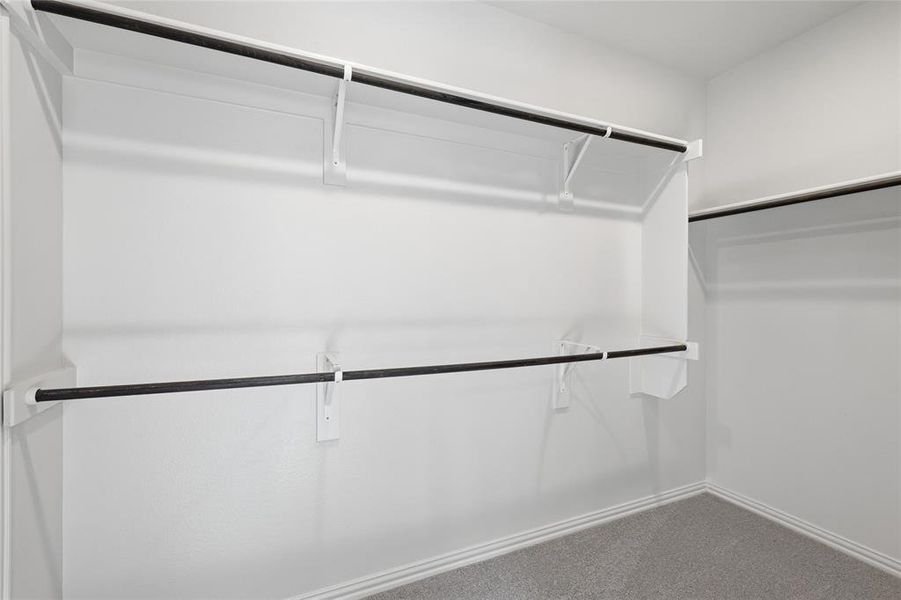 Walk in closet featuring dark colored carpet Walk in closet featuring dark colored carpet