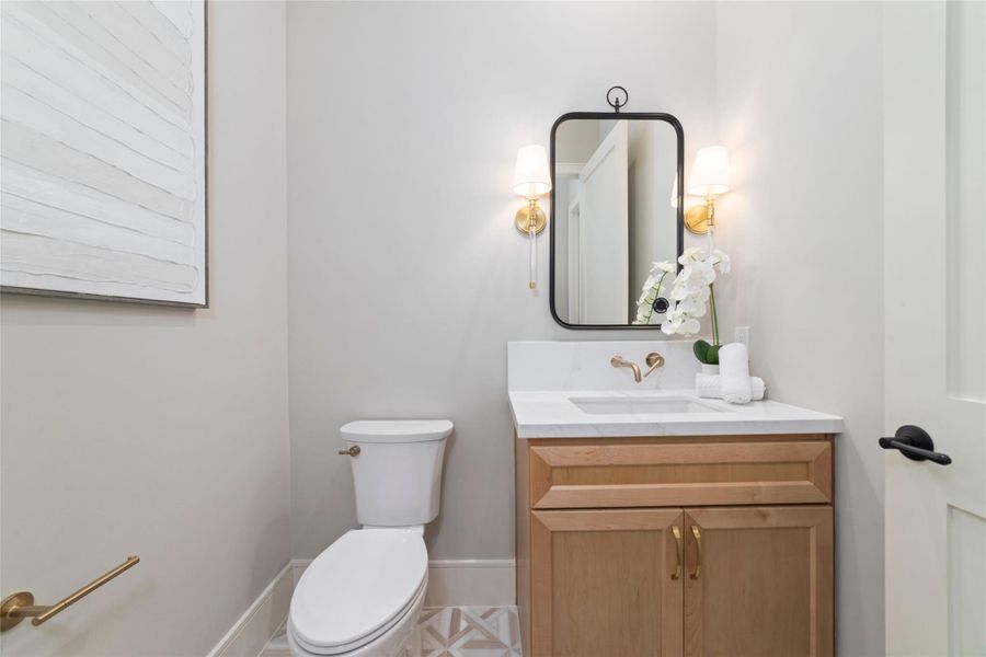 Stylish half bath featuring a modern vanity, elegant lighting, and designer finishes.
