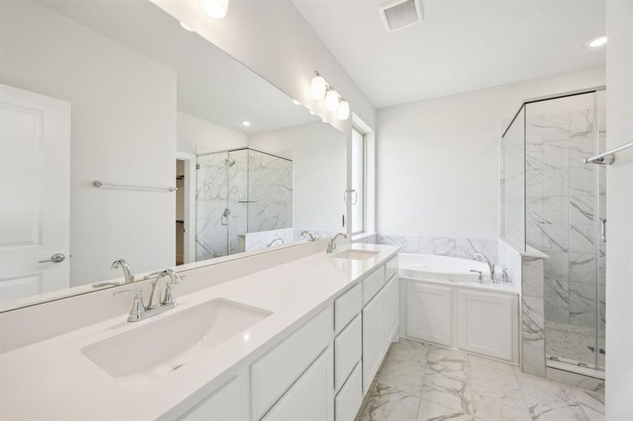 Bathroom featuring a garden tub, double vanity, a marble finish shower, light marble finish floors, and recessed lighting
