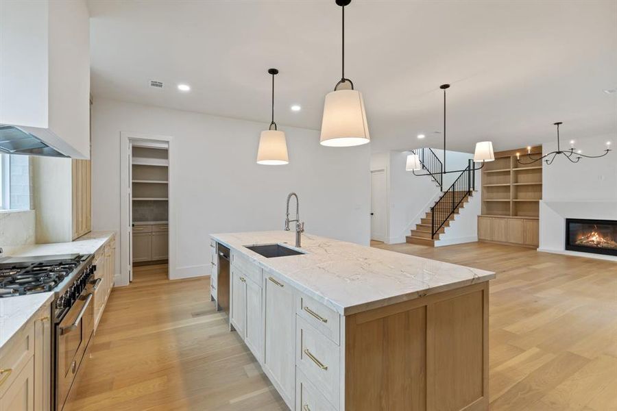 The kitchen is a true chef’s dream, featuring stunning quartzite countertops, a custom plaster vent hood, white oak custom cabinets, and Bertazzoni 48-inch range and refrigerator columns, offering both beauty and practicality.