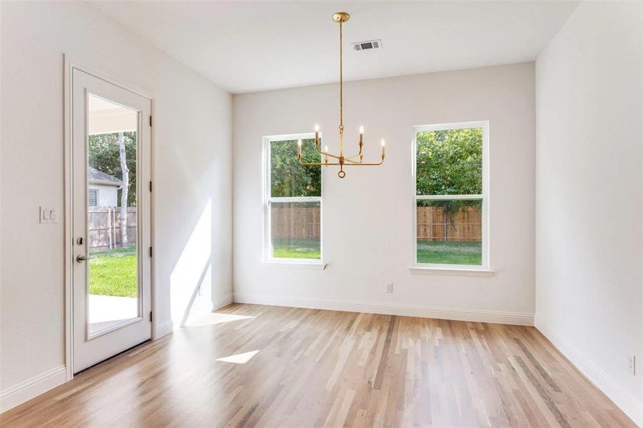 Unfurnished dining area with light wood-style floors and a chandelier