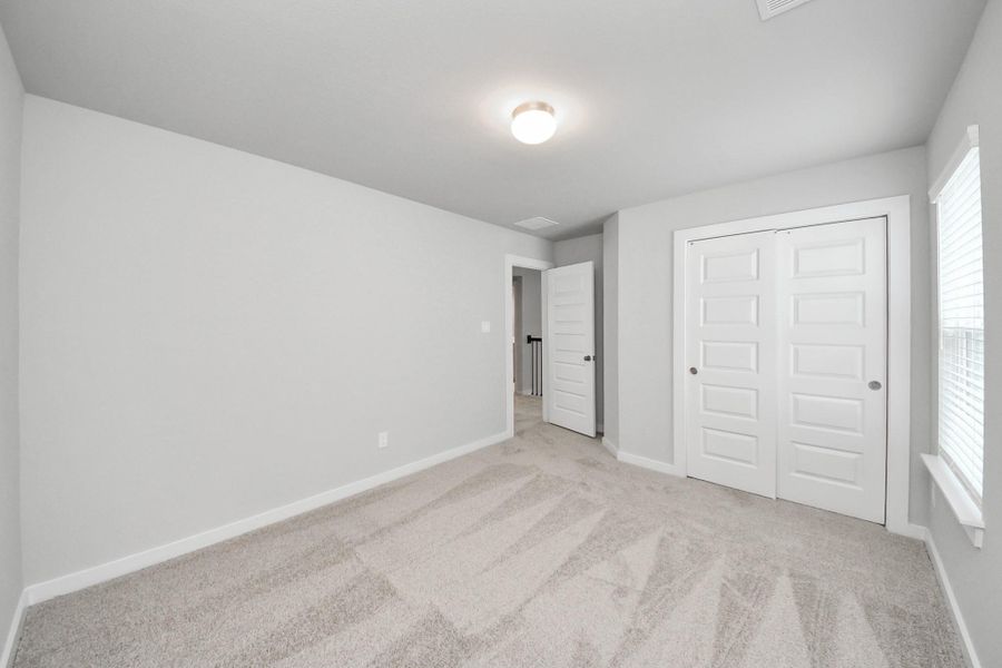 Generously sized secondary bedrooms featuring spacious closets, soft and inviting carpeting underfoot, large windows allowing plenty of natural light, and the added touch of privacy blinds for your personal retreat. Sample photo of completed home with similar floor plan. Actual colors and selections may vary.