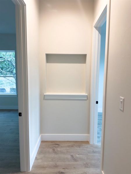An elegant hallway alcove highlights the classic molding and rich wood-style flooring. An elegant hallway alcove highlights the classic molding and rich wood-style flooring.