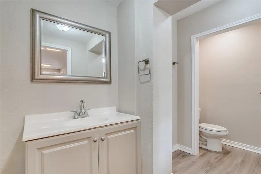 Bathroom with vanity, light wood-style floors, and a textured wall Bathroom with vanity, light wood-style floors, and a textured wall