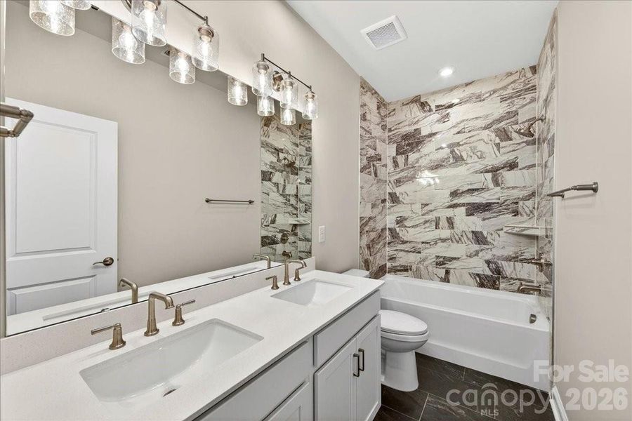 Dual Vanity secondary bathroom with tiled walls above the tub Dual Vanity secondary bathroom with tiled walls above the tub