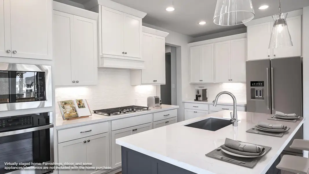 Kitchen featuring stainless steel appliances, white cabinets, a breakfast bar, and recessed lighting