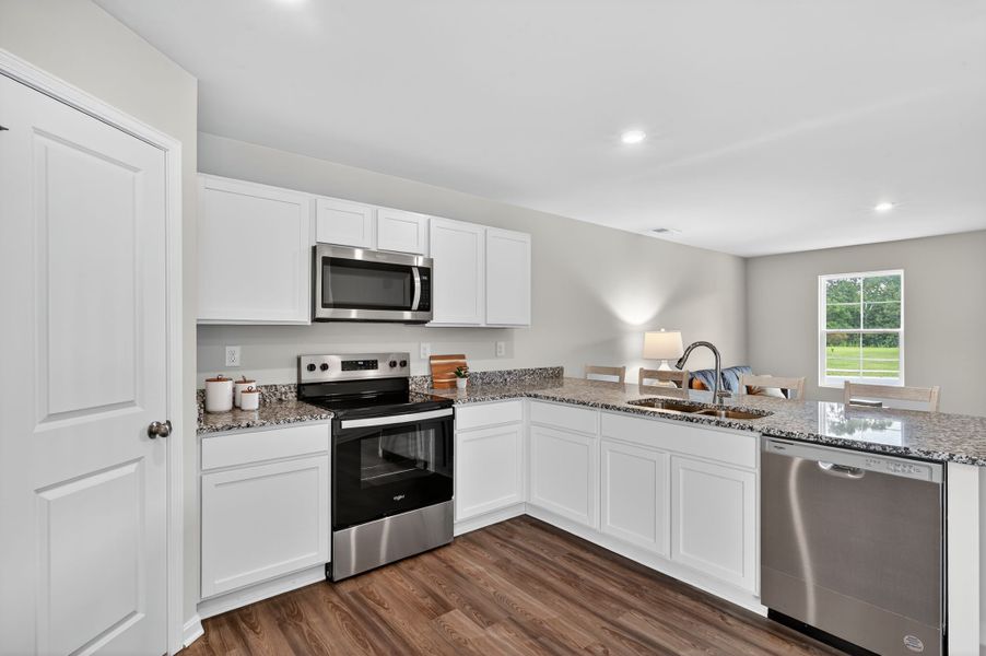 A kitchen with white cabinets.