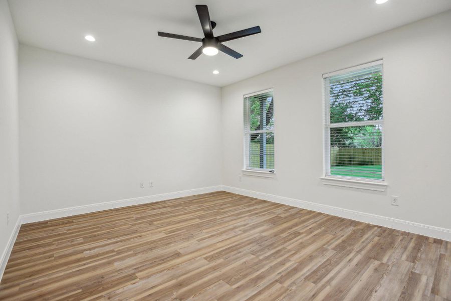 Living room with recessed lighting, vinyl wood plank floors, baseboards, and a ceiling fan