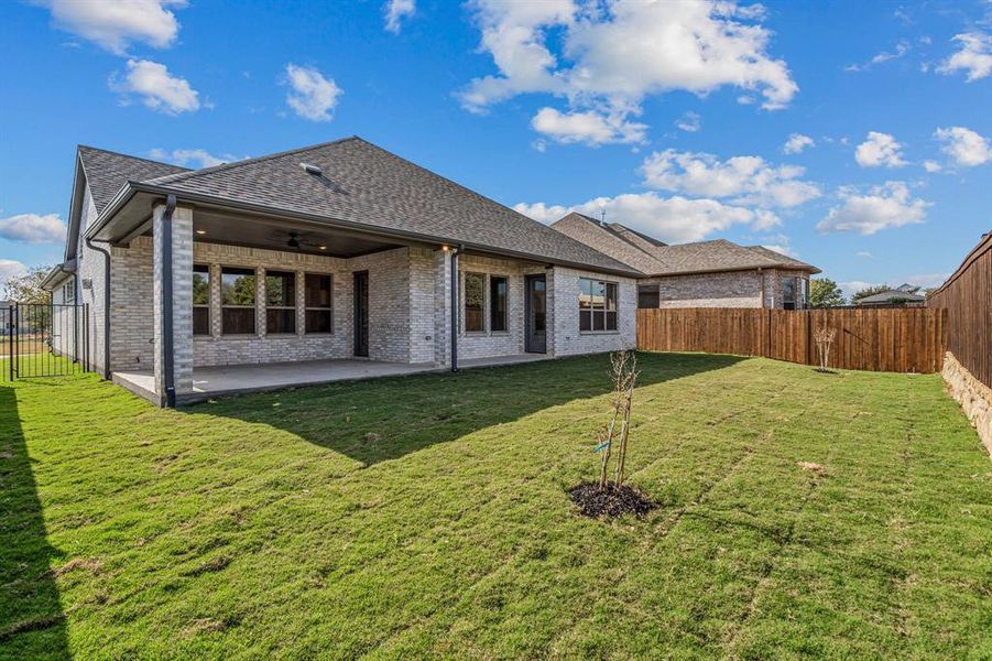 Back of house featuring brick siding, a fenced backyard, a patio area, ceiling fan, and a shingled roof