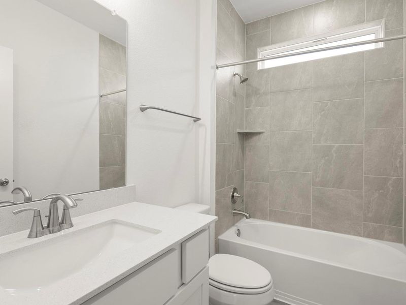 A well-appointed bathroom features a modern vanity and a tiled shower with a large window.