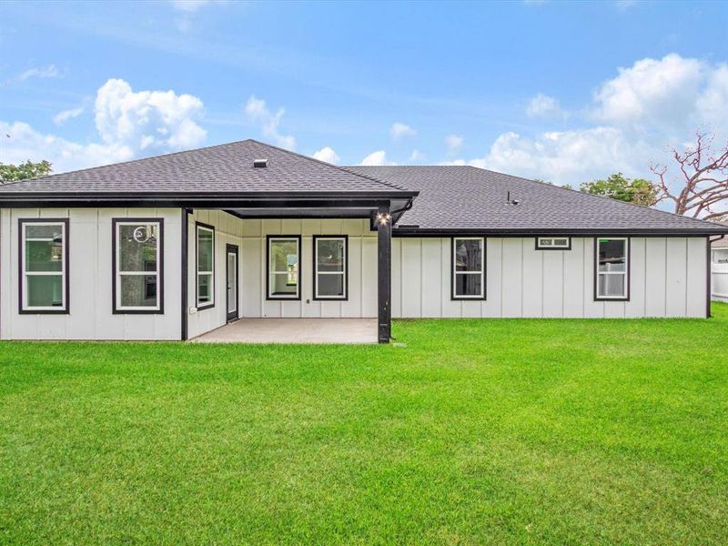 Expansive grassy yard with a concrete patio