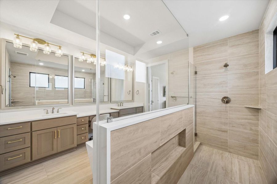 THE PRIMARY SHOWER INCLUDES FRAMELESS GLASS, FULL-HEIGHT TILE, BUILT-IN LEDGES, AND A GENEROUS WALK-IN DESIGN ADJACENT TO THE DUAL VANITIES. THE PRIMARY SHOWER INCLUDES FRAMELESS GLASS, FULL-HEIGHT TILE, BUILT-IN LEDGES, AND A GENEROUS WALK-IN DESIGN ADJACENT TO THE DUAL VANITIES.