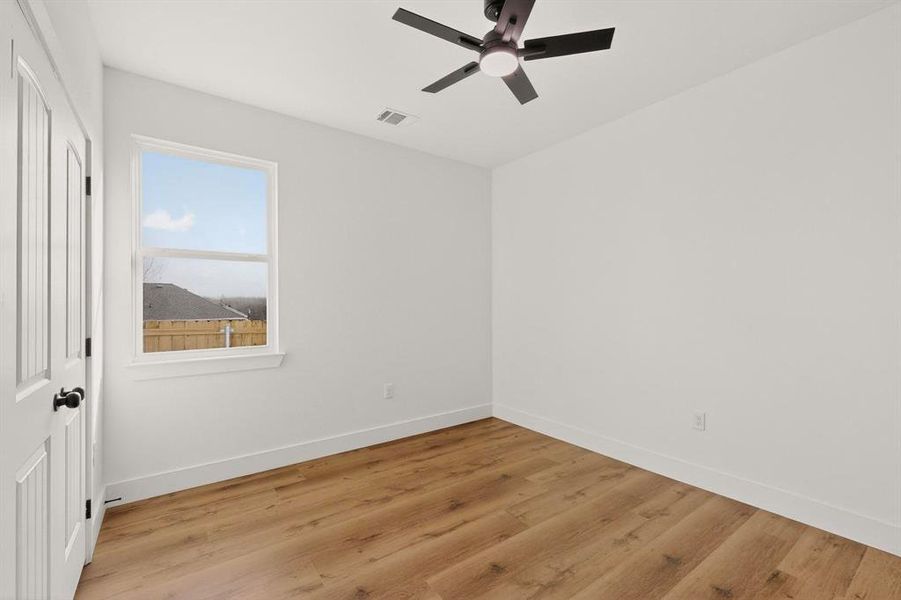 Unfurnished bedroom featuring wood finished floors, a ceiling fan, and a closet Unfurnished bedroom featuring wood finished floors, a ceiling fan, and a closet