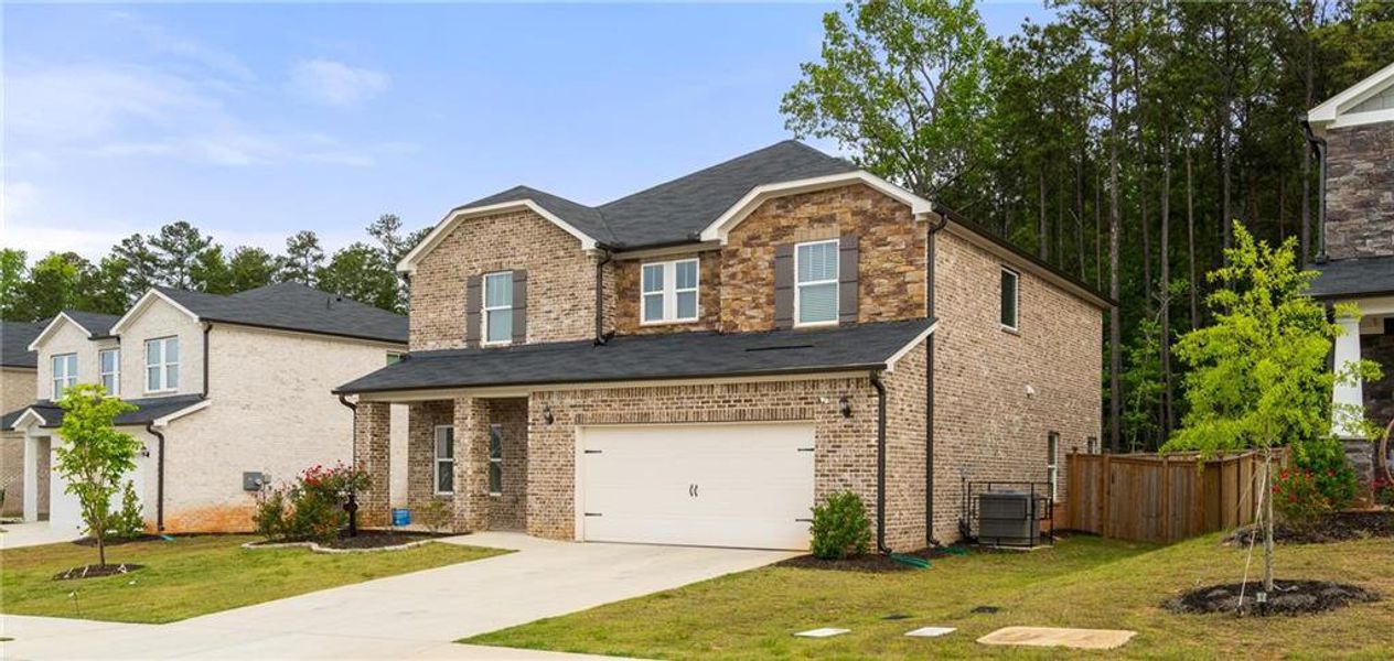 Front exterior of a new home in Creekside at Oxford Park, Fairburn, GA, highlighting curb appeal (Image 2). Front exterior of a new home in Creekside at Oxford Park, Fairburn, GA, highlighting curb appeal (Image 2).