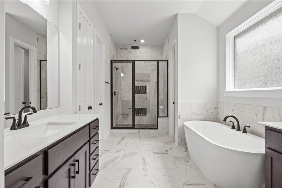 Bathroom with a marble finish shower, vanity, a freestanding tub, marble finish floors, and recessed lighting Bathroom with a marble finish shower, vanity, a freestanding tub, marble finish floors, and recessed lighting