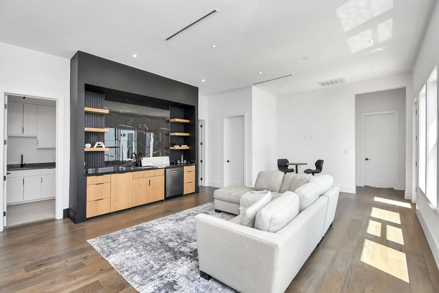 Wet bar features European cabinetry, dishwasher, and sink.