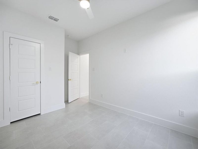 Unfurnished bedroom featuring a ceiling fan and light tile patterned floors