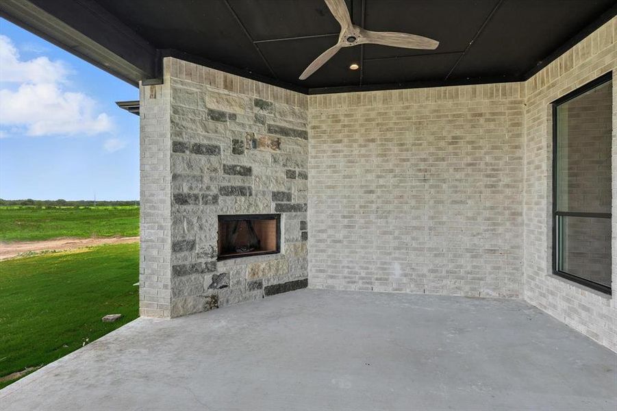 View of patio featuring an outdoor stone fireplace and ceiling fan View of patio featuring an outdoor stone fireplace and ceiling fan