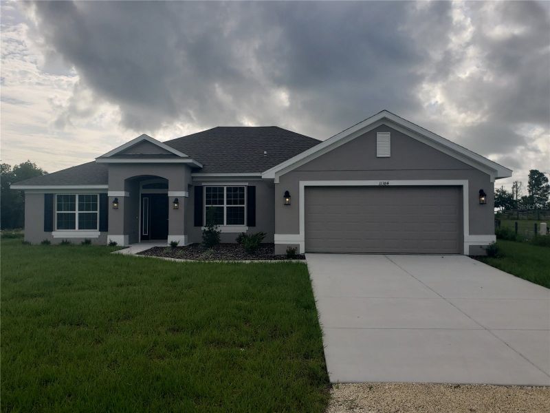 Front exterior of a new home in Royal Highlands, Weeki Wachee, FL, highlighting curb appeal (Image 1).