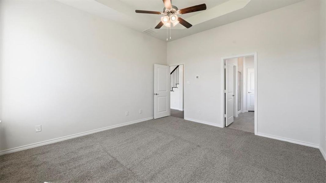 Unfurnished bedroom featuring carpet, a ceiling fan, and a high ceiling Unfurnished bedroom featuring carpet, a ceiling fan, and a high ceiling