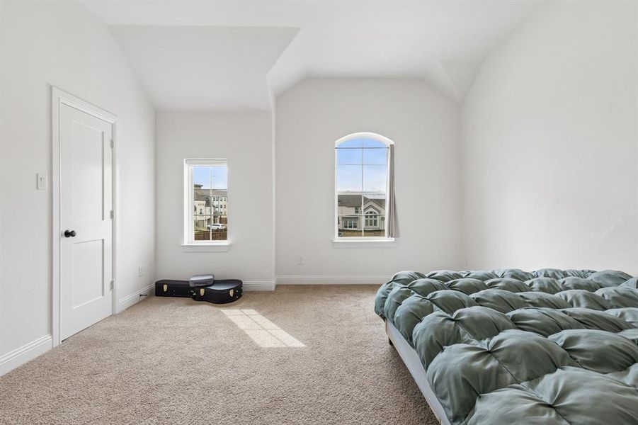 Carpeted room featuring a double-pane arched window and a standard double-pane window