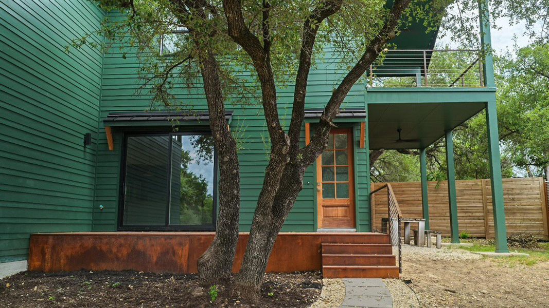 A striking nature green exterior highlights this residence, featuring a covered patio and an upper-level balcony for elevated outdoor enjoyment. A striking nature green exterior highlights this residence, featuring a covered patio and an upper-level balcony for elevated outdoor enjoyment.