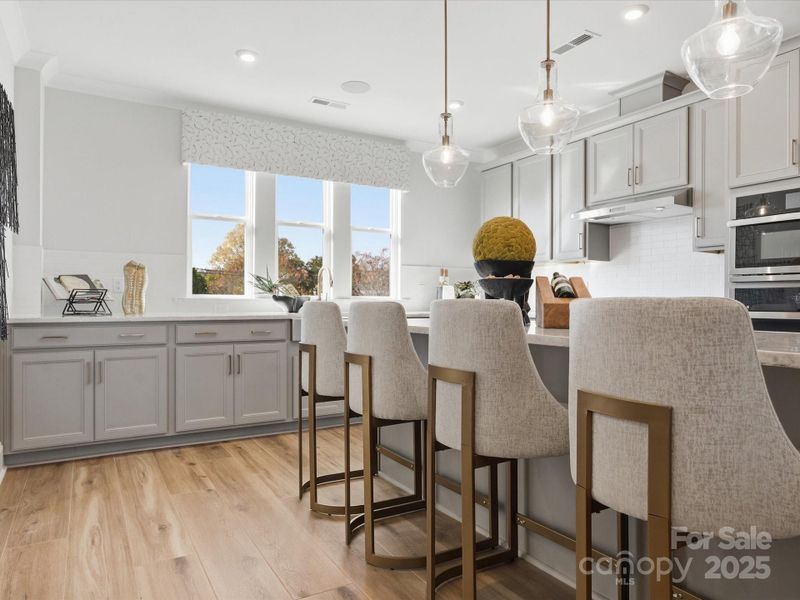 Designer Pendant Lighting and Large Windows Brighten Up the Space. *Model Photos | Actual Finishes, Structural Selections, and Orientation May Vary.